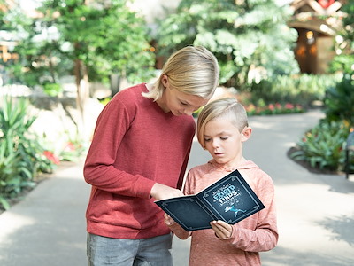 Family looking at scavenger hunt map in gardens at Gaylord Texan