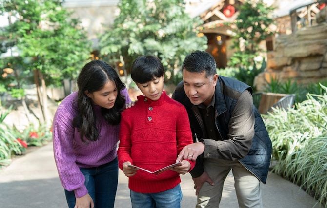Family looking at scavenger hunt map in atrium gardens at Gaylord National