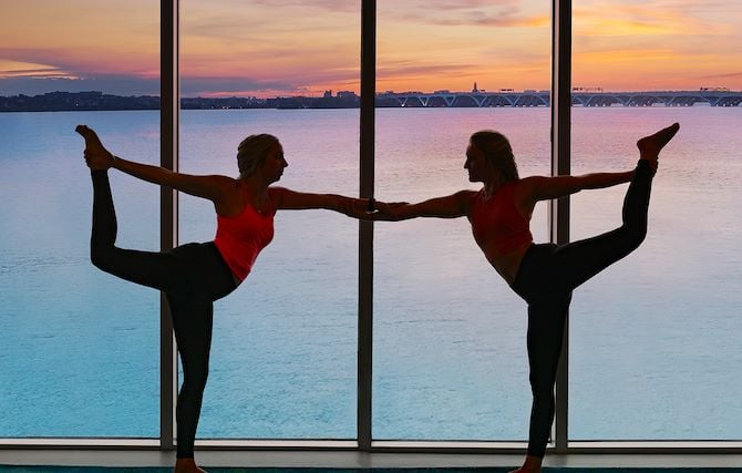 Two women in yoga poses overlooking Potomac River at Gaylord National