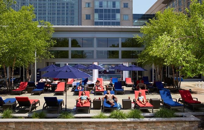 Guests on lounge chairs on pool deck at Gaylord National