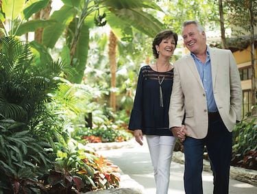 Senior couple holding hands walking Gaylord National atrium