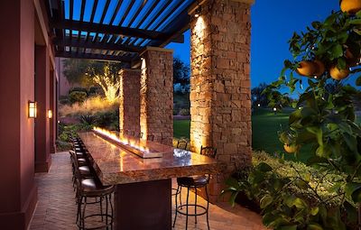 Long outdoor table with fire feature running down the center of the table.